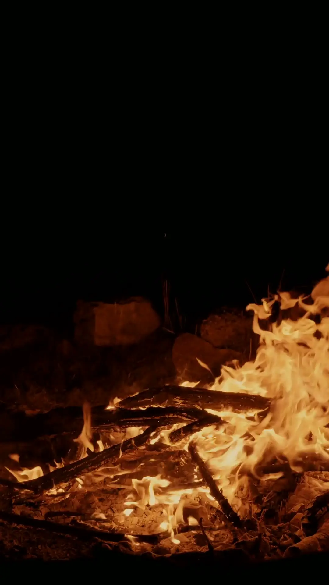 Low amber flames glowing in the dark