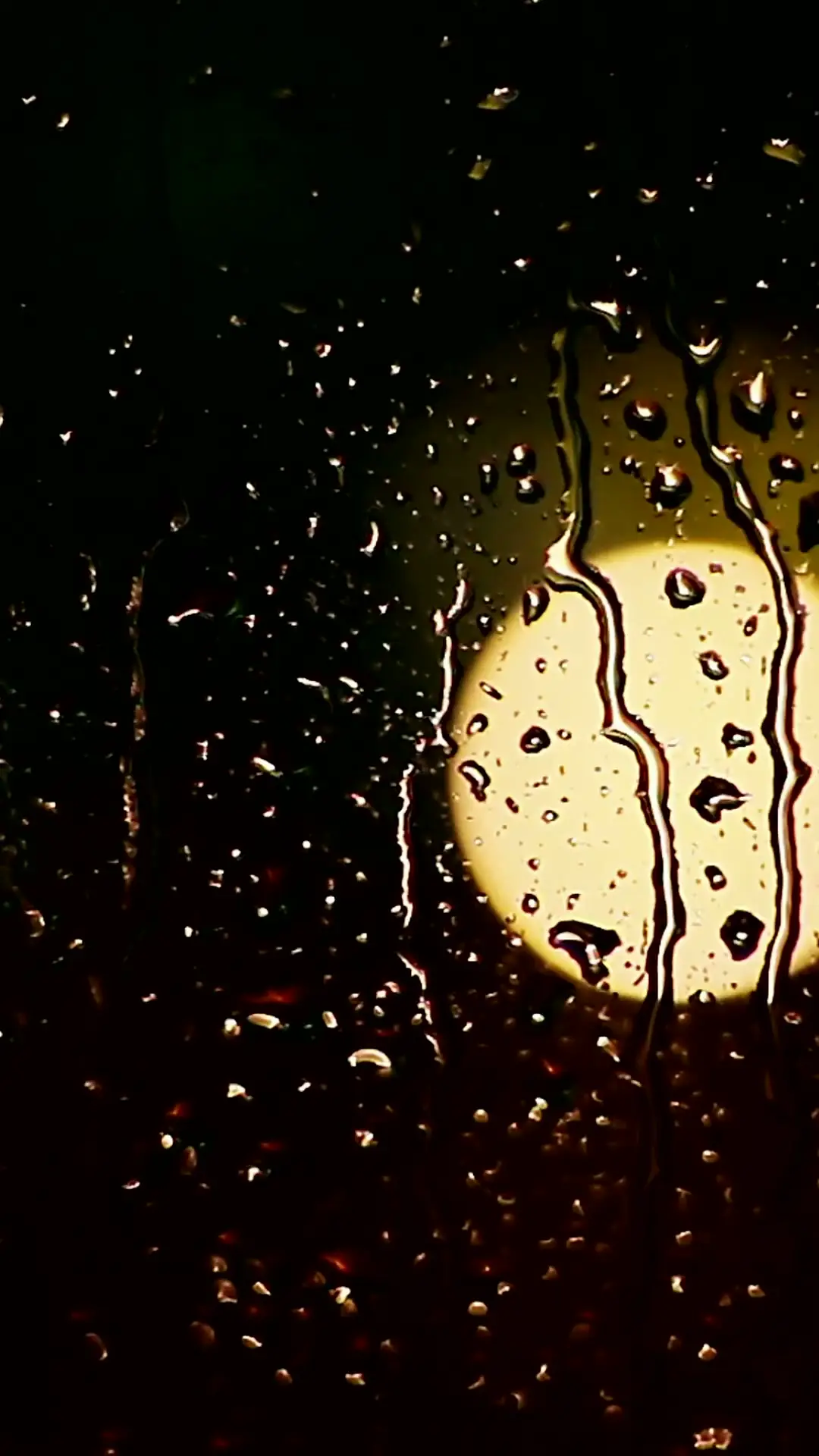 Rain moving down a window at night